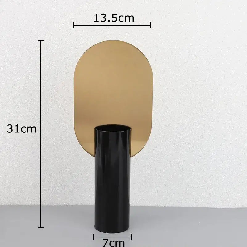 Modern geometric cylinder vase with sleek black base and reflective gold panel featuring pink artificial flowers decorbites geometric cylinder vase