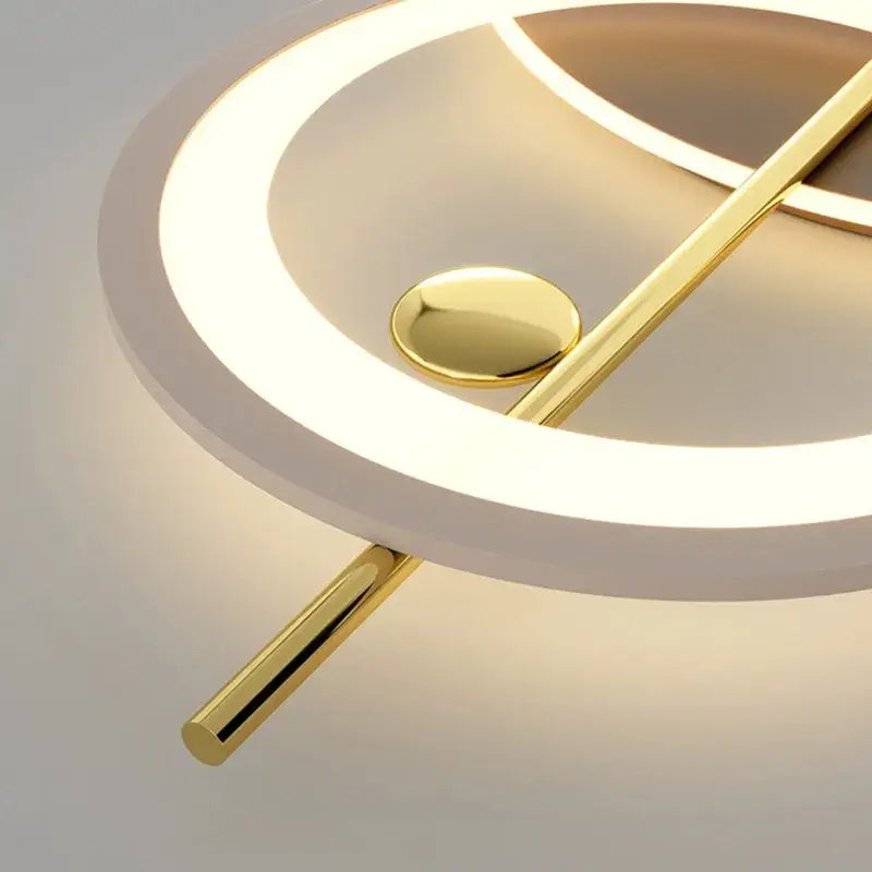 Modern geometric decorbites led wall sconce featuring a circular white illuminated ring with gold-toned metallic rods