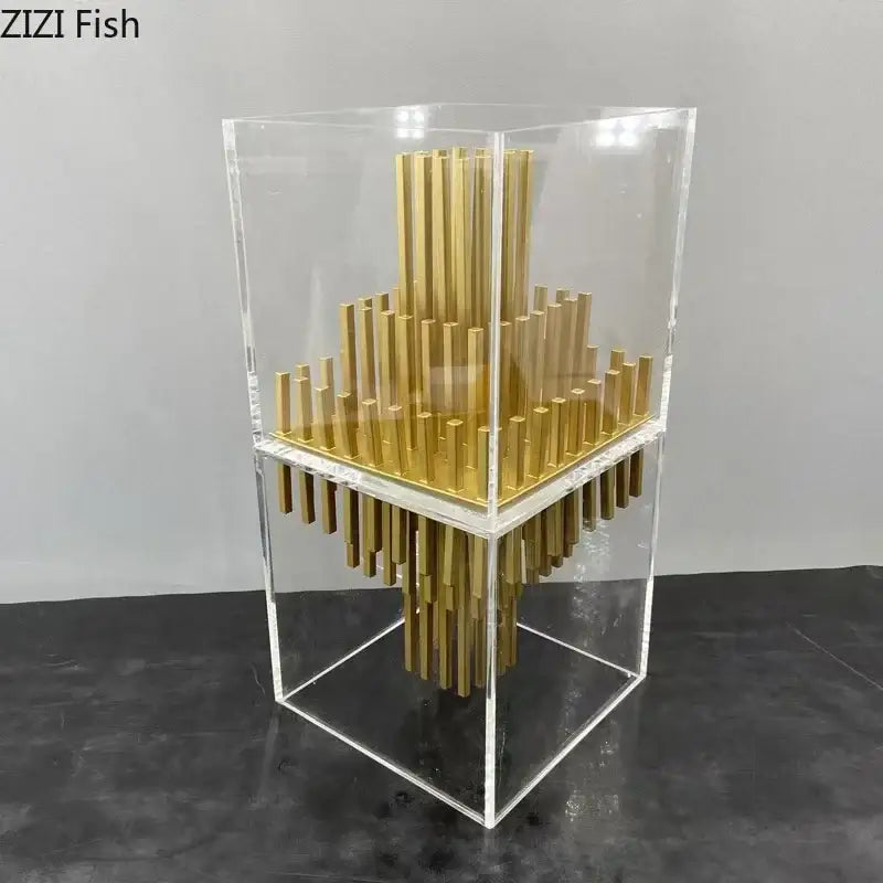 Modern geometric display box featuring gold metallic rods in a tiered pattern inside a transparent acrylic cube
