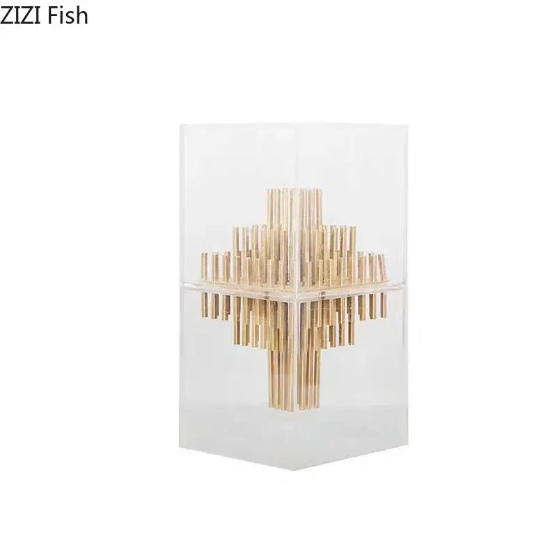 A modern geometric display box with gold metal bamboo sticks in a transparent acrylic case for living room decor