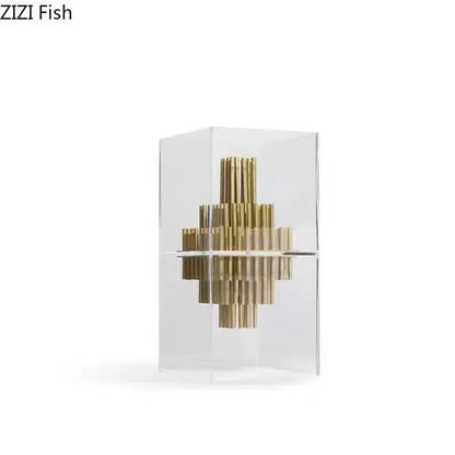 A modern geometric display box featuring golden brass rods in a transparent acrylic case for living room decor