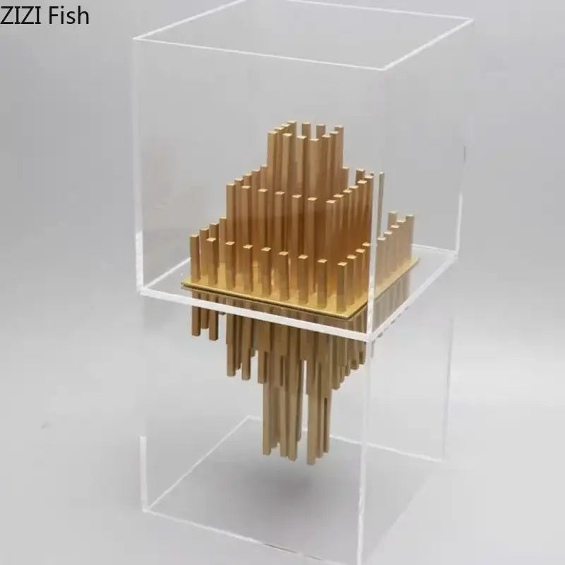Modern geometric display box featuring a gold metal sculpture with tiered vertical rods inside a clear acrylic case
