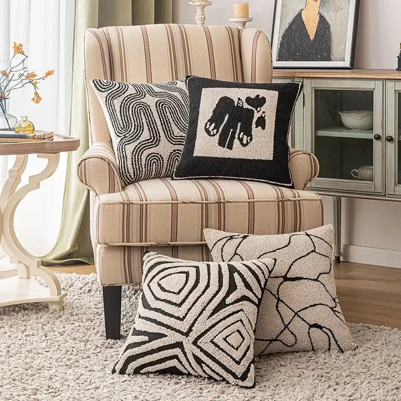 Beige and brown striped wingback armchair with black and white decorbites geometric embroidered cushion covers