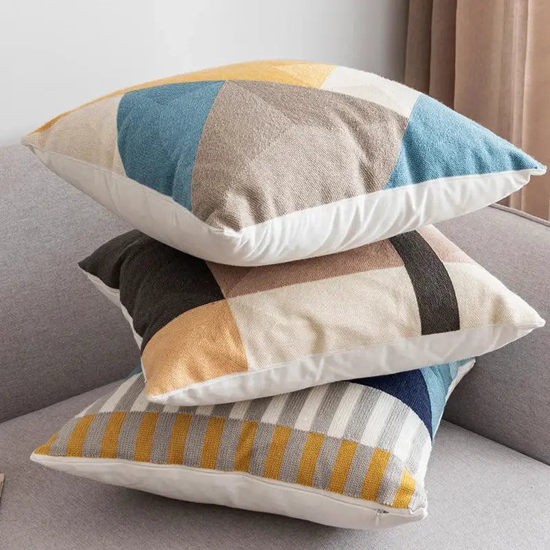 Stacked modern throw pillows with decorbites geometric embroidery in muted blues beige and mustard yellow for living room decor