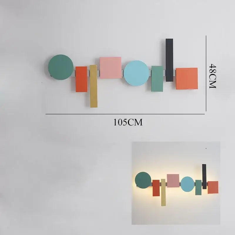 A modern geometric flush mount wall sconce with colorful flat-cut shapes in teal coral pink and mustard yellow