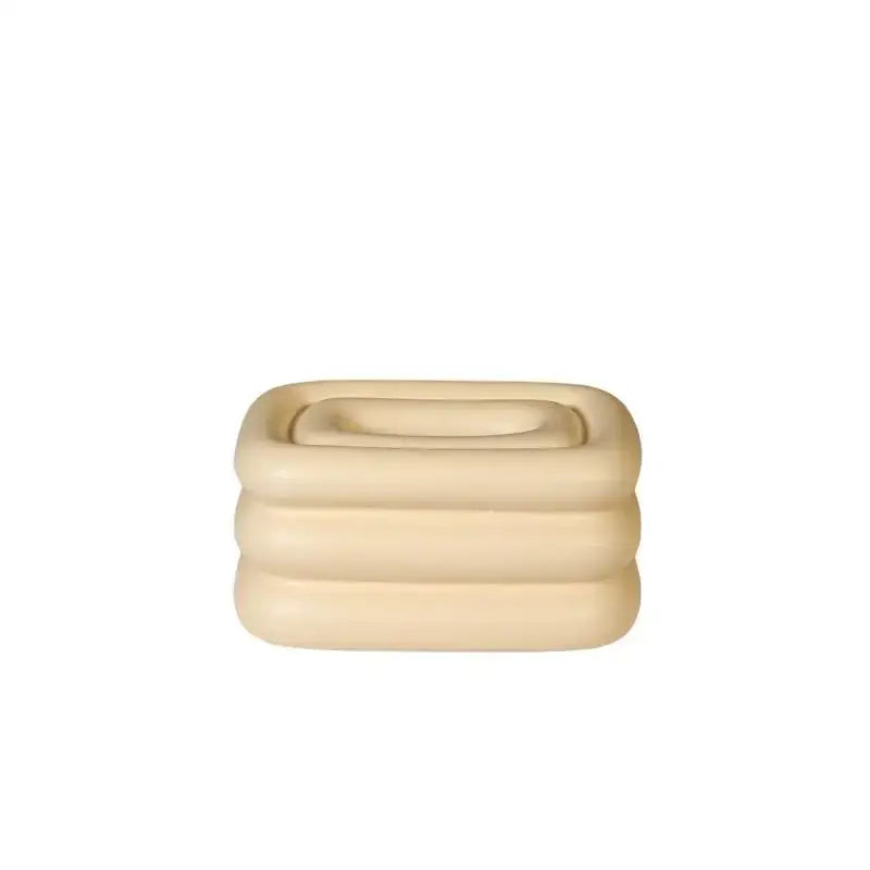 Cream-colored layered inflatable pool toy with square shape and rounded edges complements tissue box geometric fringe decorbites