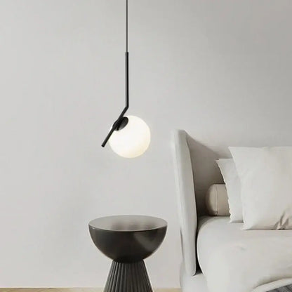 Minimalist black glass pendant light with frosted globe and sleek metal arm for bedroom bedside chandeliers