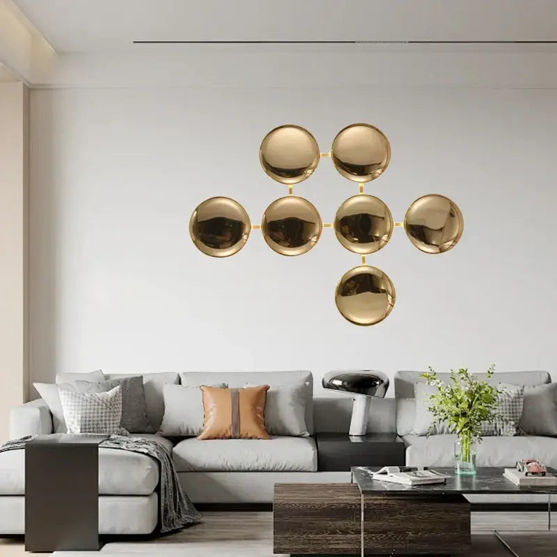 Modern geometric glossy gold led wall sconces featuring gold-toned spherical wall art with minimalist design