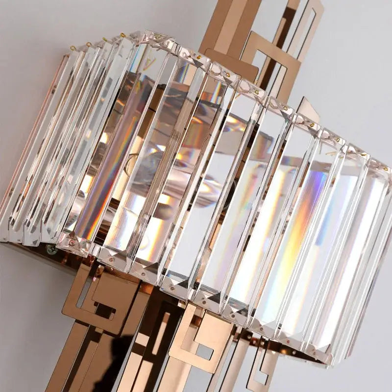 Modern geometric gold crystal wall lamp featuring vertical crystal prisms in a rose gold metal frame decorbites crystal wall lamp