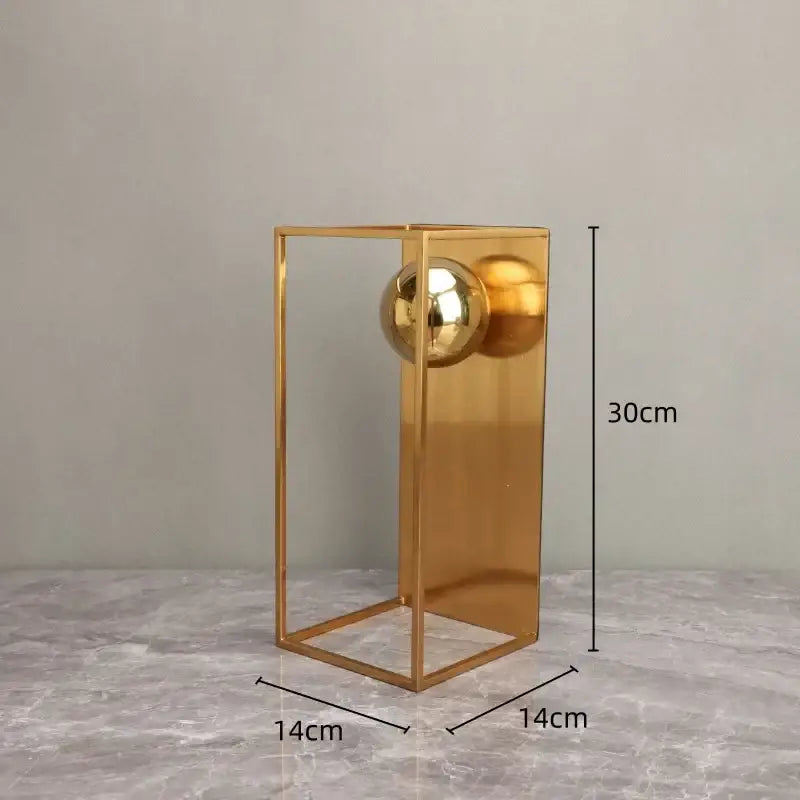 A sleek gold-toned geometric gold frame decorative figurine with reflective spheres for living room decor
