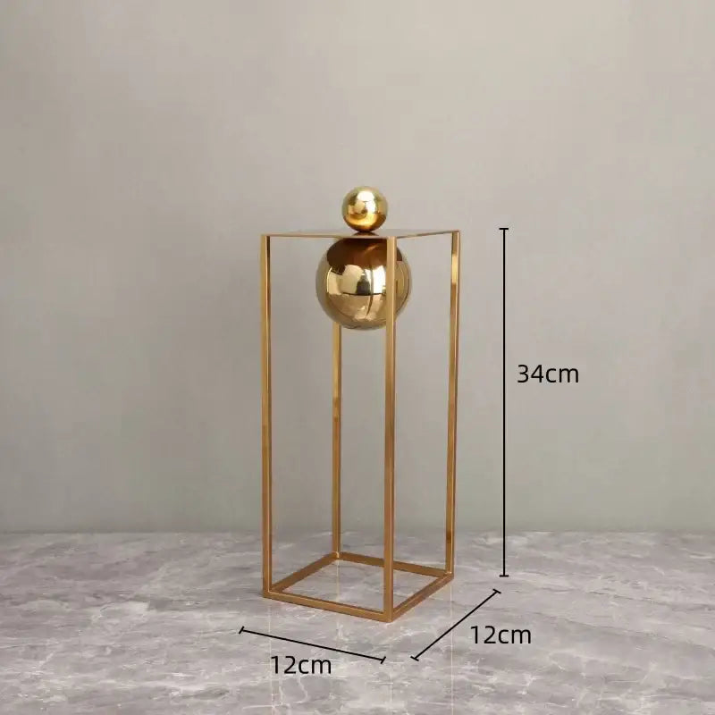 Golden metallic decorative figurines featuring a geometric gold frame with stacked spheres for living room decor