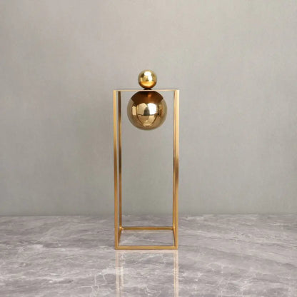 Modern geometric gold frame decorative figurines with gold metallic spheres balanced in a minimalist geometric gold frame sculpture
