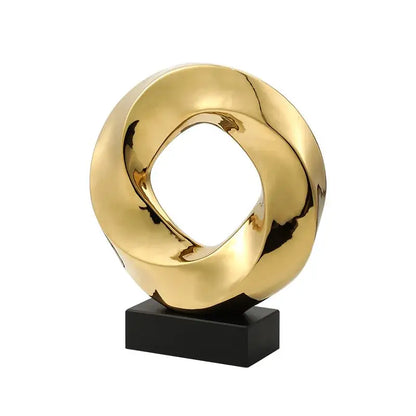Golden glossy geometric gold hollowed abstract sculpture with twisted ring design on black base for home decor