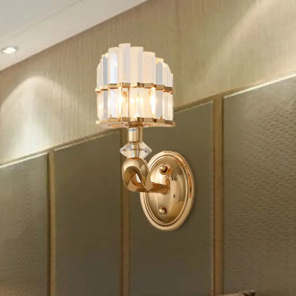Modern geometric gold wall lamp with tiered clear crystal panels and polished brass base for living room sconce