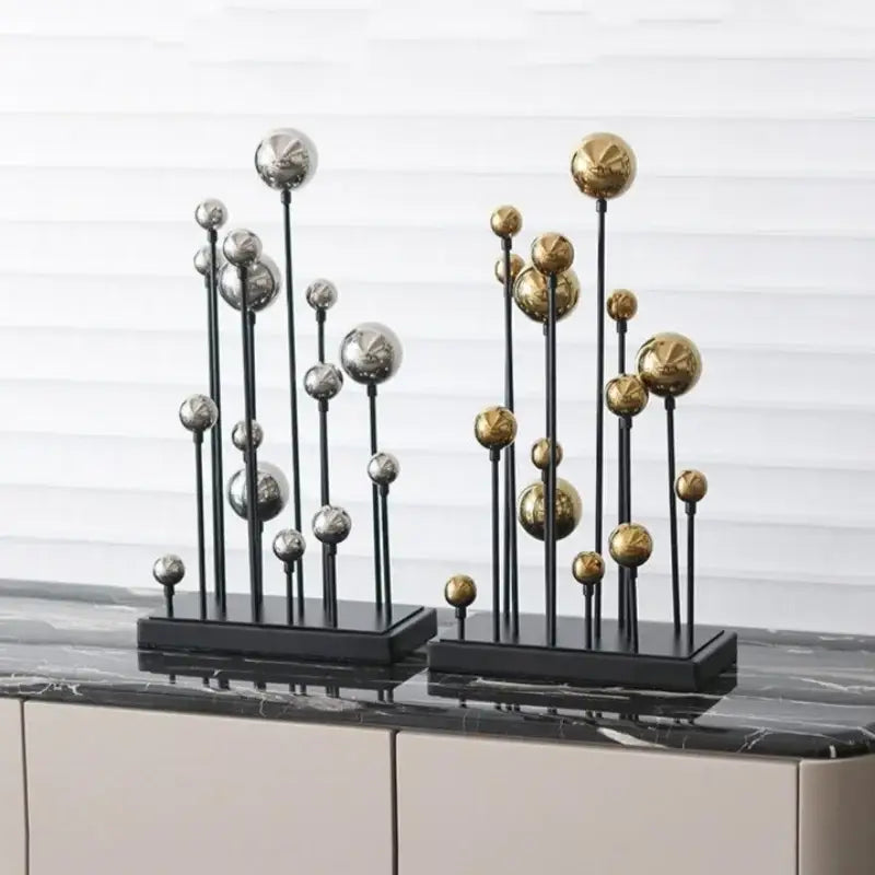 Modern geometric golden ball sculpture with polished silver and gold metallic spheres on black stems for living room decor