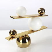 Modern gold-toned metal geometric golden ball seesaw ramp sculpture with polished spheres and flat platforms for living room decorbites decor