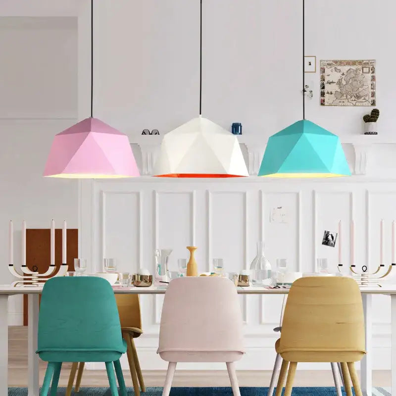 Three modern geometric iron diamond pendant lights in pink white orange and teal hang above a dining table decorbites iron diamond pendant