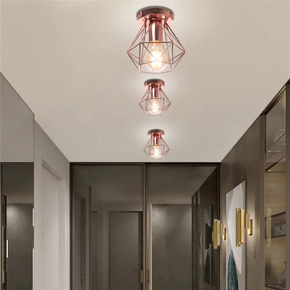 Three rose gold modern geometric ceiling lights with iron frame cage design featuring exposed bulbs for aisle and loft decorbites iron frame cage