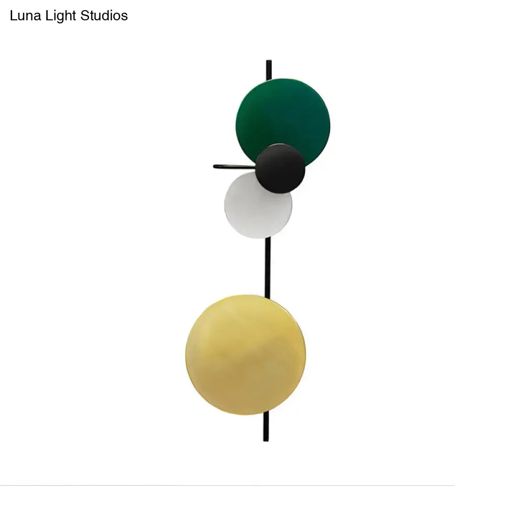 Modern geometric led wall light with stacked circular shades in green black white yellow on sleek black rod for living room use