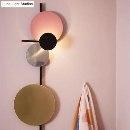 Modern geometric led wall light with stacked circular shades in matte pink black mirrored silver and brushed gold for living room