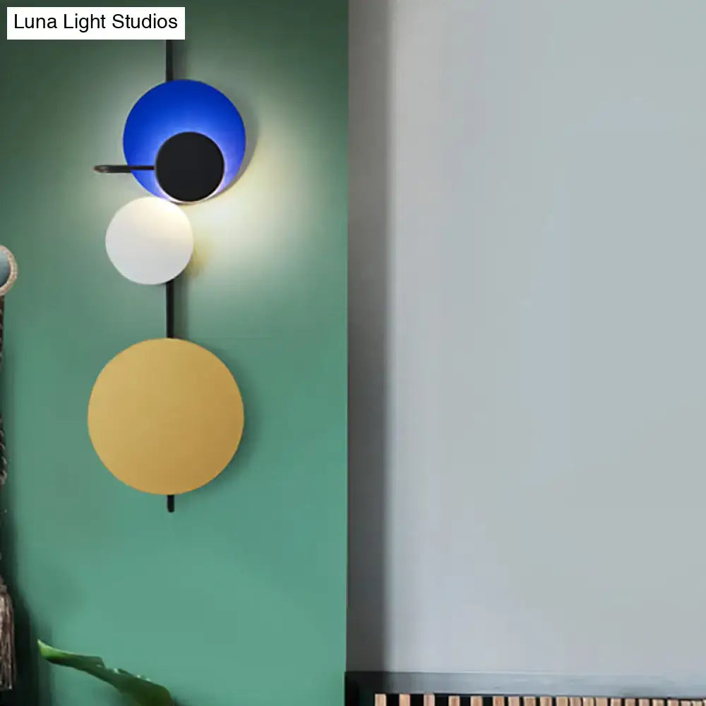 Modern geometric led wall light with three stacked circular shades in blue white and mustard yellow for living room use
