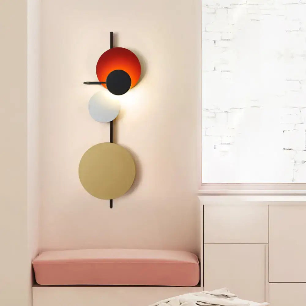 Modern geometric led wall light living room sconce with stacked orange black white beige discs on black rod in red pink blue tones