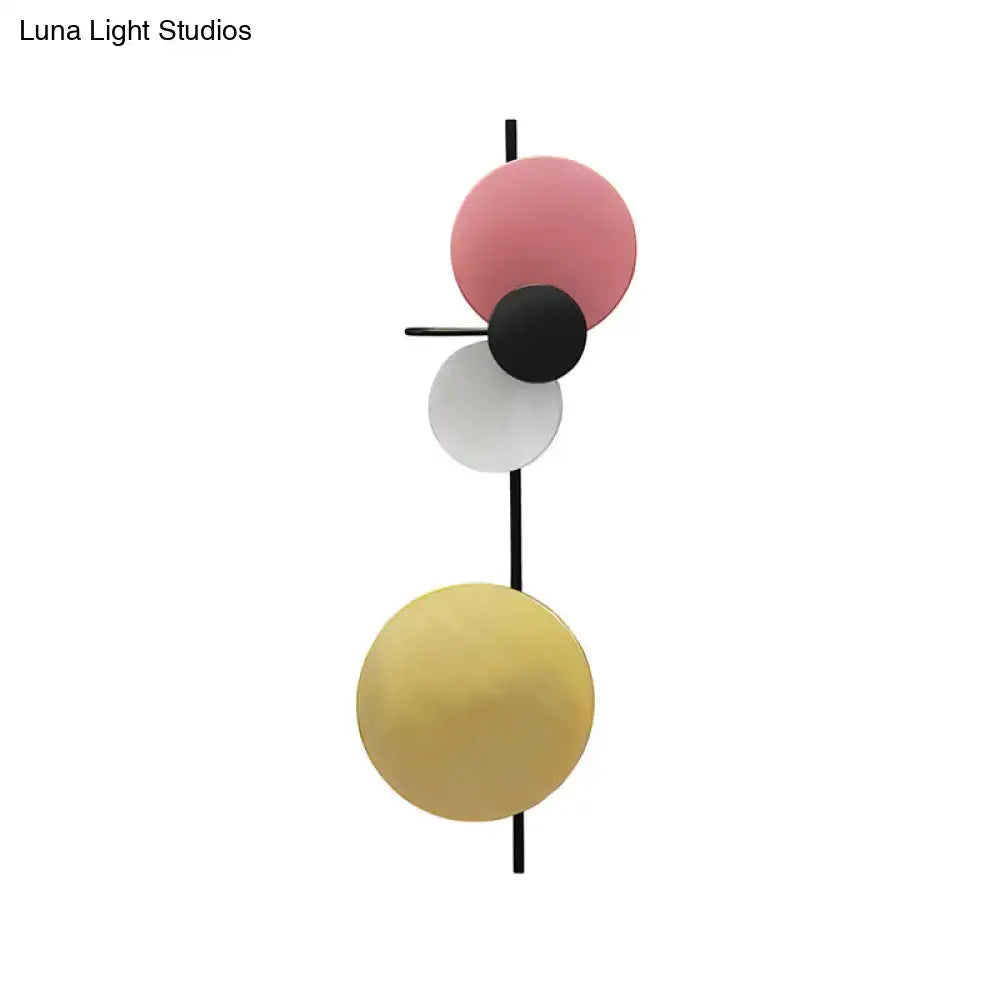 Modern geometric led wall light with stacked matte pink, black, white, and gold spherical shades for living rooms in red pink blue