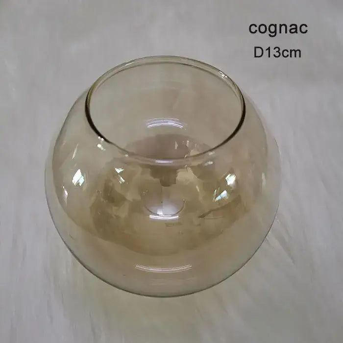 A translucent cognac-colored glass bowl with a smooth rounded shape in modern geometric magic bean lighting design