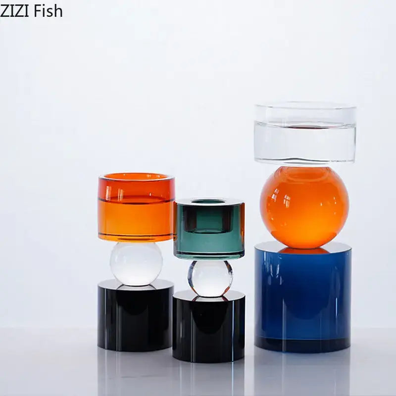 Set of three modern geometric orange and black crystal candle holders with colorful glass vases and transparent spheres