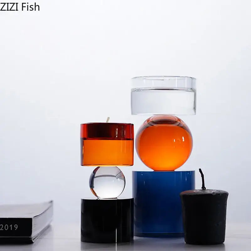 A vibrant orange crystal candle with glossy finish atop a deep blue base in modern geometric candle holders