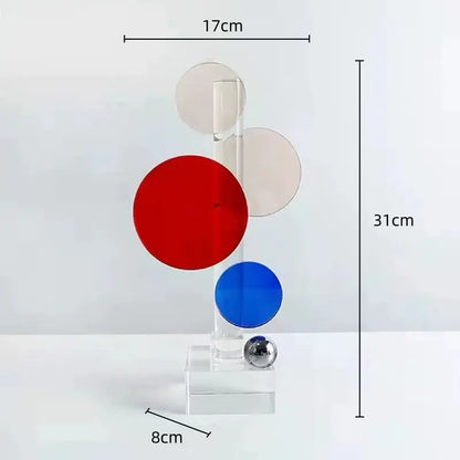 A modern geometric ring acrylic sculpture with red blue and beige discs on a clear base for home decor by decorbites crystal geometric