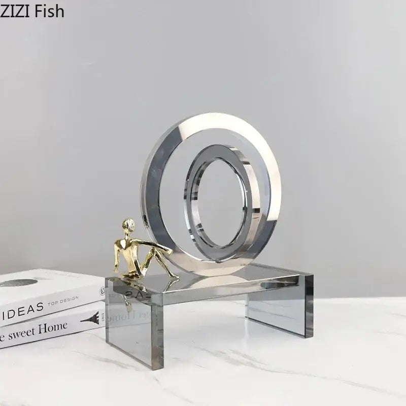 Modern geometric ring chair featuring a shiny chrome circular sculpture with a miniature golden figure on a ring chair base