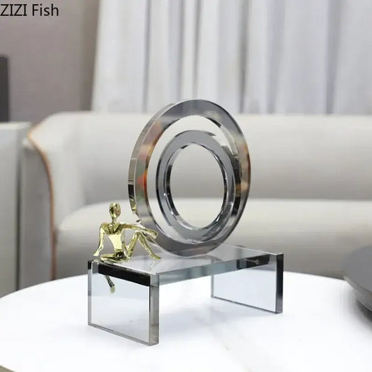 A modern geometric ring chair sculpture with polished chrome ring and gold figurine on a transparent ring chair base