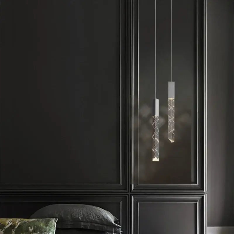 Two modern minimalist silver pendant lights with decorbites crystal glass led bodies feature geometric etched patterns