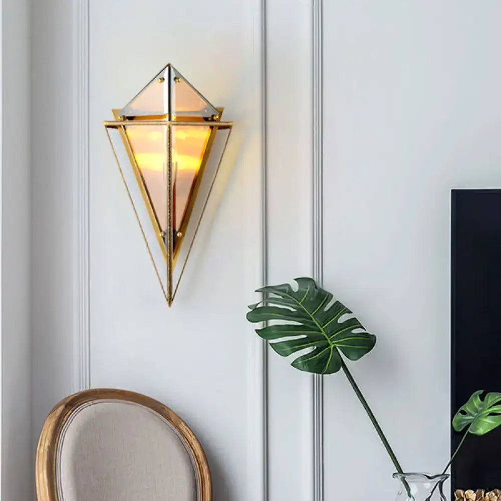 Modern geometric smoke gray led wall lamp with gold-toned triangular glass panels emitting warm glow living room sconce