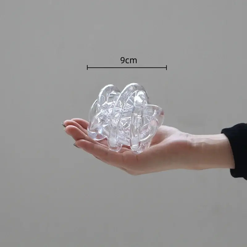 Clear transparent plastic hair claw with intricate twisted design resembling a modern geometric coil wound ball decor