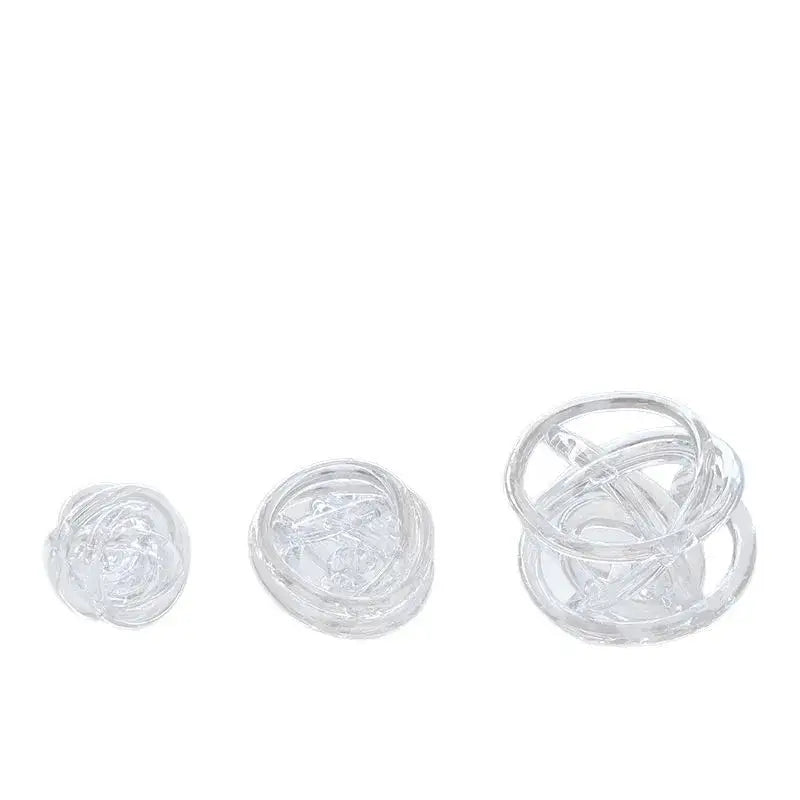 Clear glass coil wound ball with intricate twisted design as modern geometric living room decor orb
