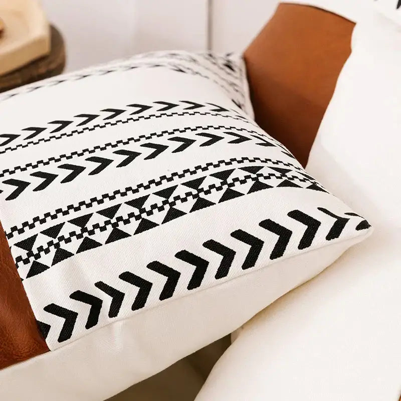 Modern geometric white and black cushion cover with tassels featuring chevrons and triangles on textured fabric decorbites brown faux