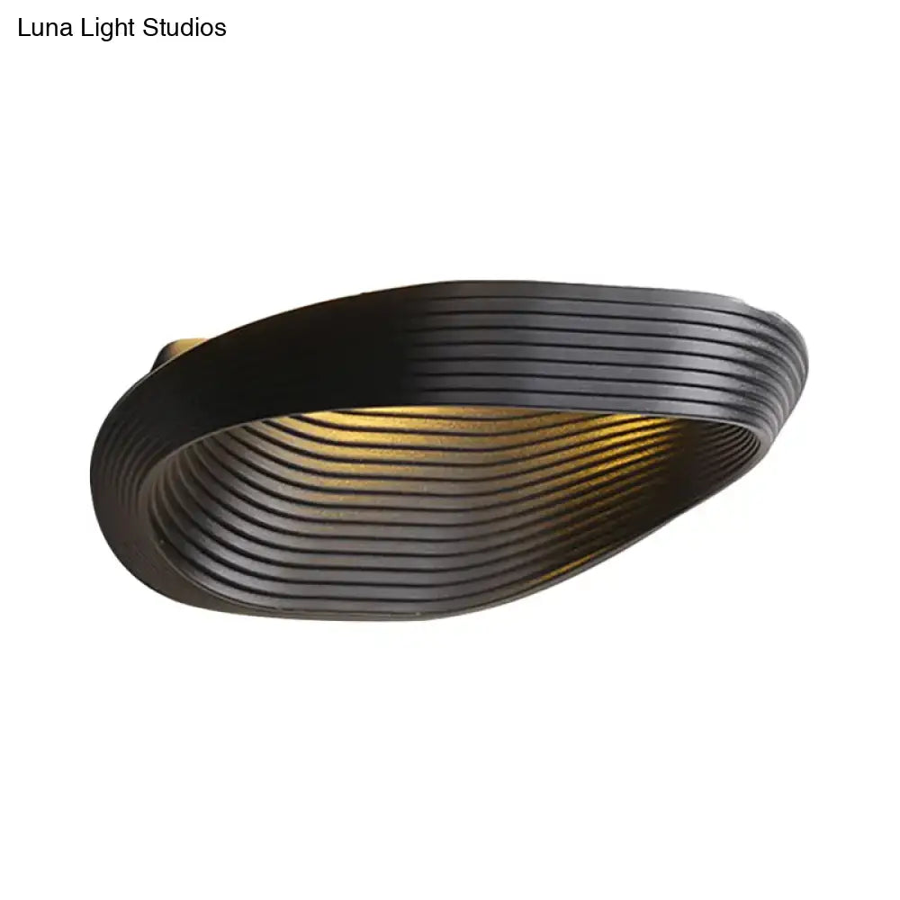 Black ribbed modern geometric wall light with warm white light ideal for bedroom lighting design