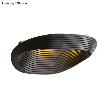 Black ribbed modern geometric wall light with warm white light ideal for bedroom lighting design
