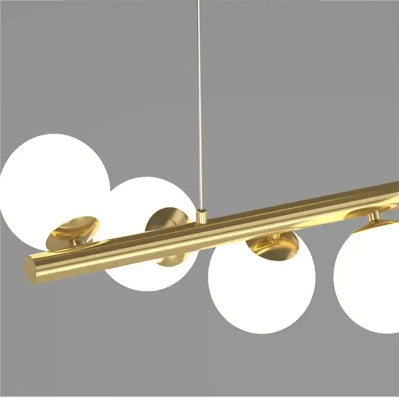 Modern glass ball gold chandelier with four frosted glass globes suspended from a sleek bar for dining room decorbites glass ball