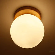 Warm-toned modern glass ball led ceiling lamp with frosted glass globe and natural wood mount for bedroom decorbites decor