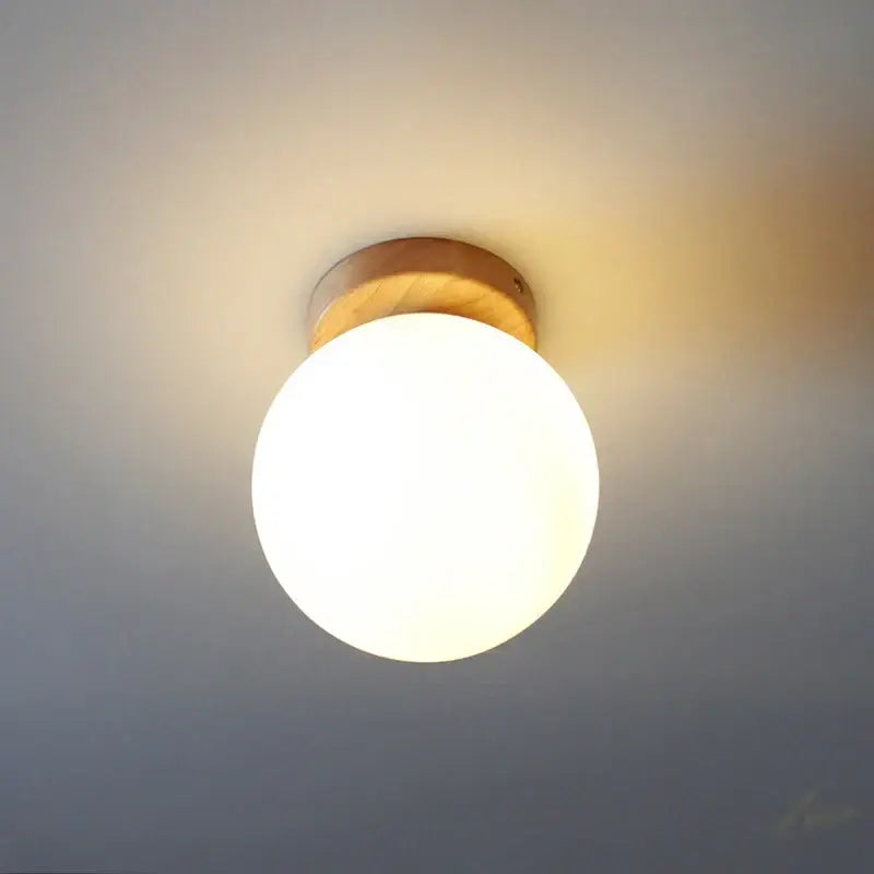 Modern glass ball led ceiling lamp with warm-toned frosted glass globe and natural wood mount for bedroom decorbites glass ball