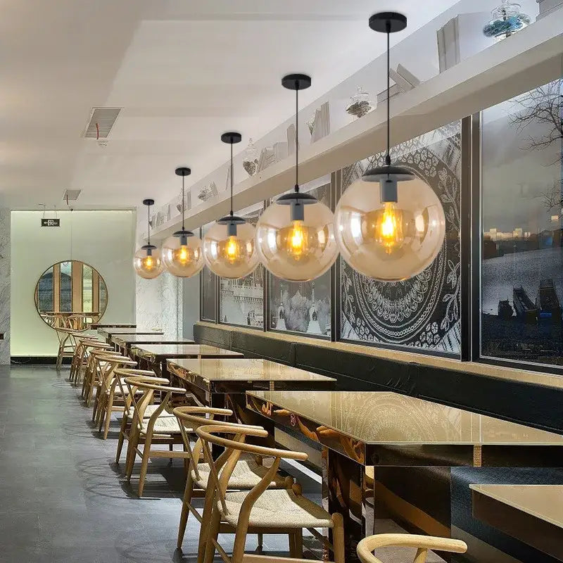 Modern glass ball led pendant lights with warm-toned spherical glass and black metal fixtures for dining room decorbites decor