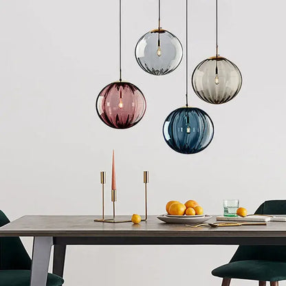 Modern glass ball lustre pendant lights feature four frosted gray rose and blue glass balls above a dining table