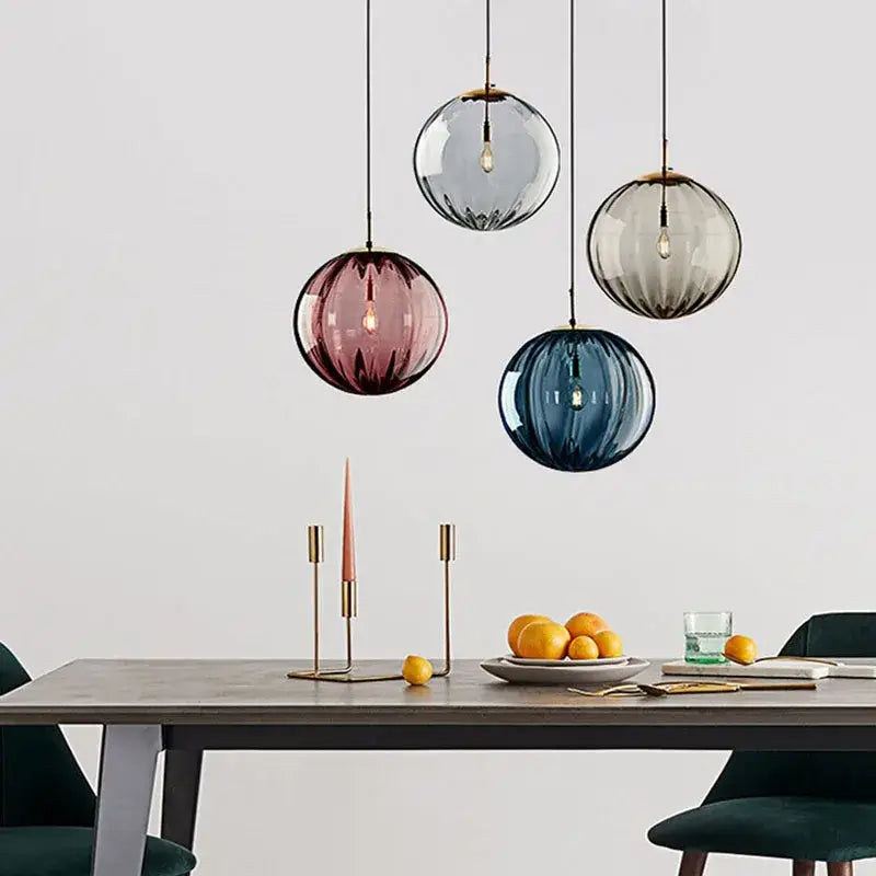 Modern glass ball lustre pendant lights feature four frosted gray rose and blue glass balls above a dining table