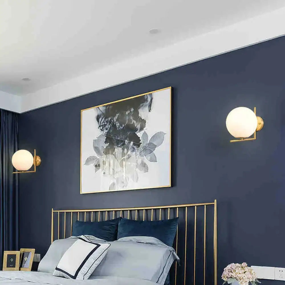 Modern glass ball wall lamp with gold-framed abstract black and gray inkblot art on white background decorbites glass ball