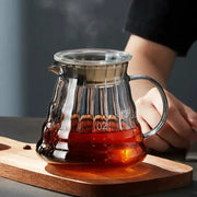 Modern glass coffee carafe with metallic lid and handle filled with rich amber liquid by decorbites glass coffee
