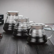 Modern glass coffee pot with stainless steel lid and handle featuring volume indicators for kitchen dining use