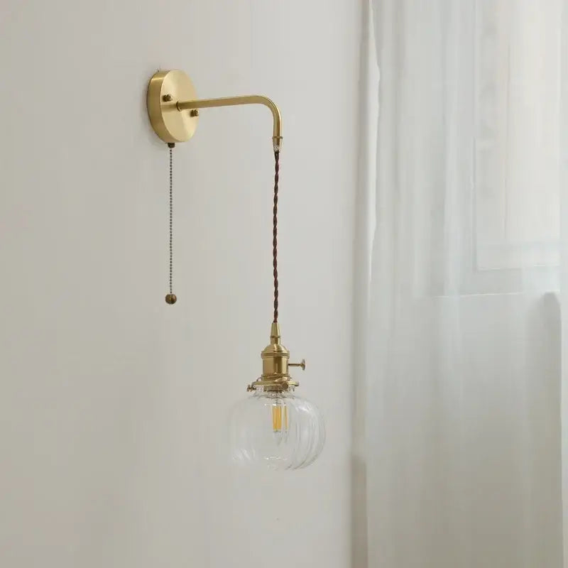 Brass wall lights with a clear ribbed glass globe and dark brown braided cord for modern glass copper led wall decor